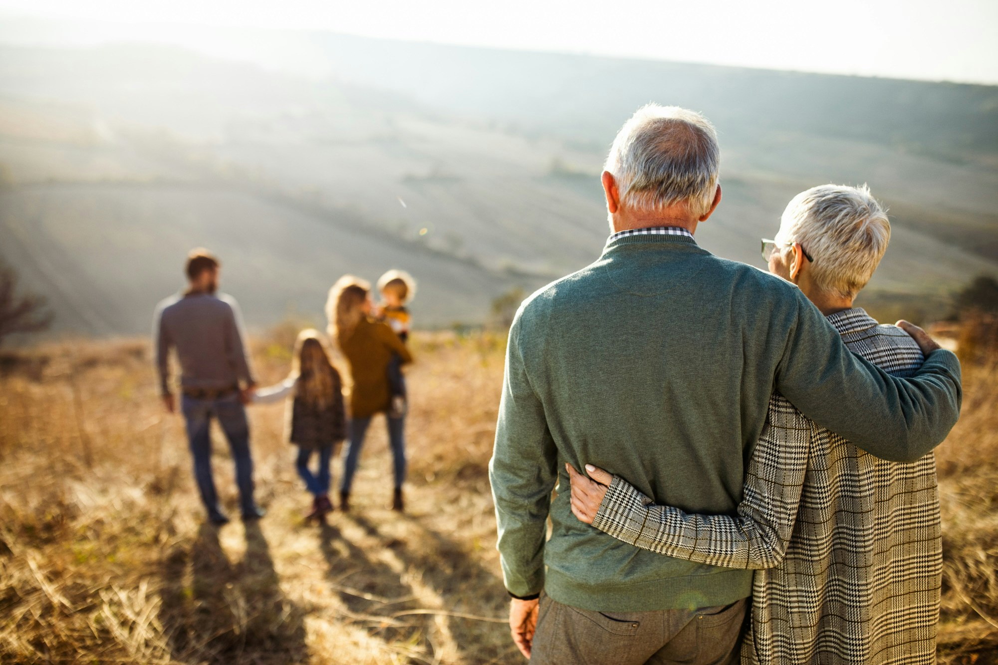 Embraced grandparents on walk with family outside