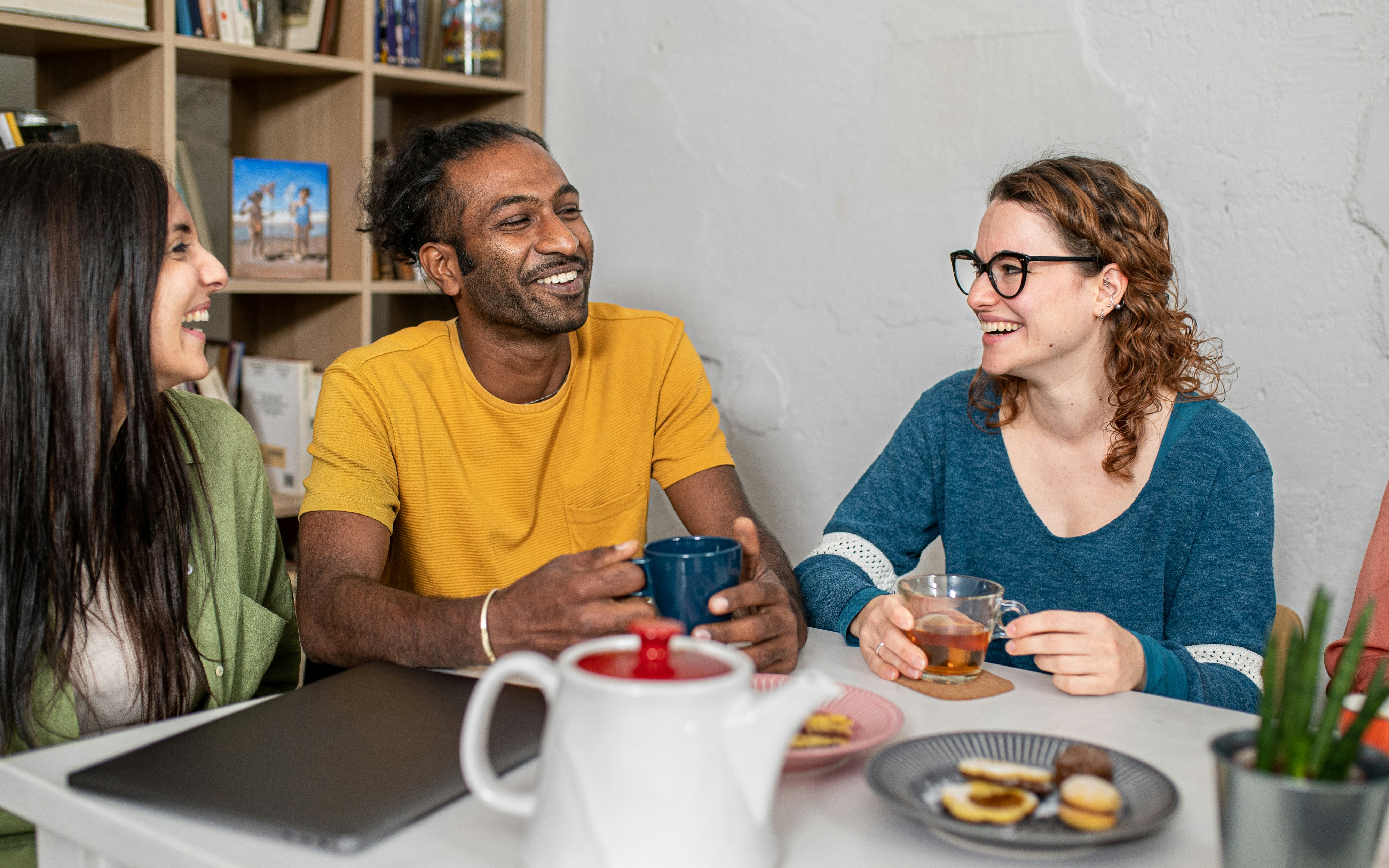 Young multiracial friends hangout in coffee shop, happy taking a break to drink coffee and eat cakes