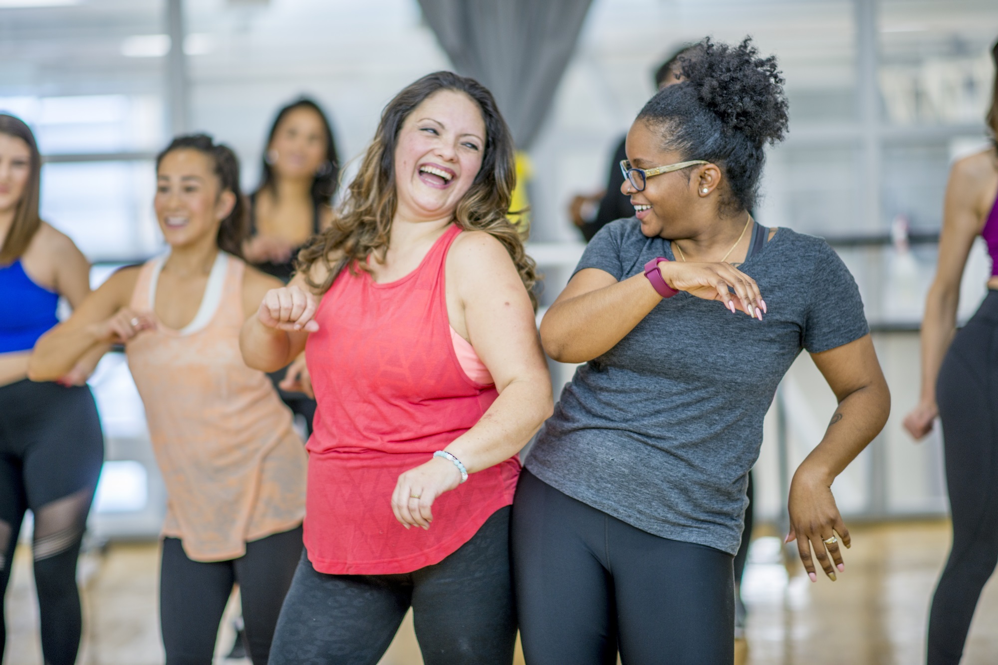 A group of women dance together in an exercise class.
