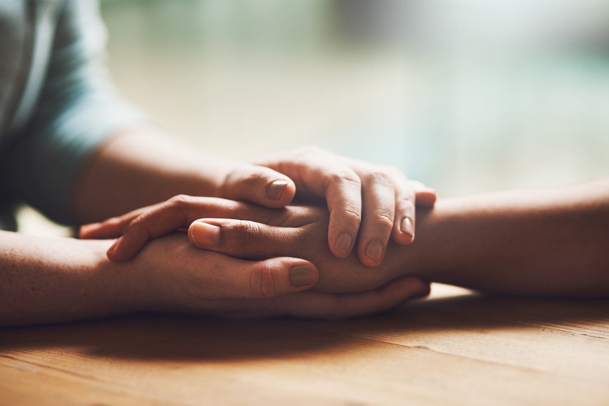 Image of two people holding hands in comfort