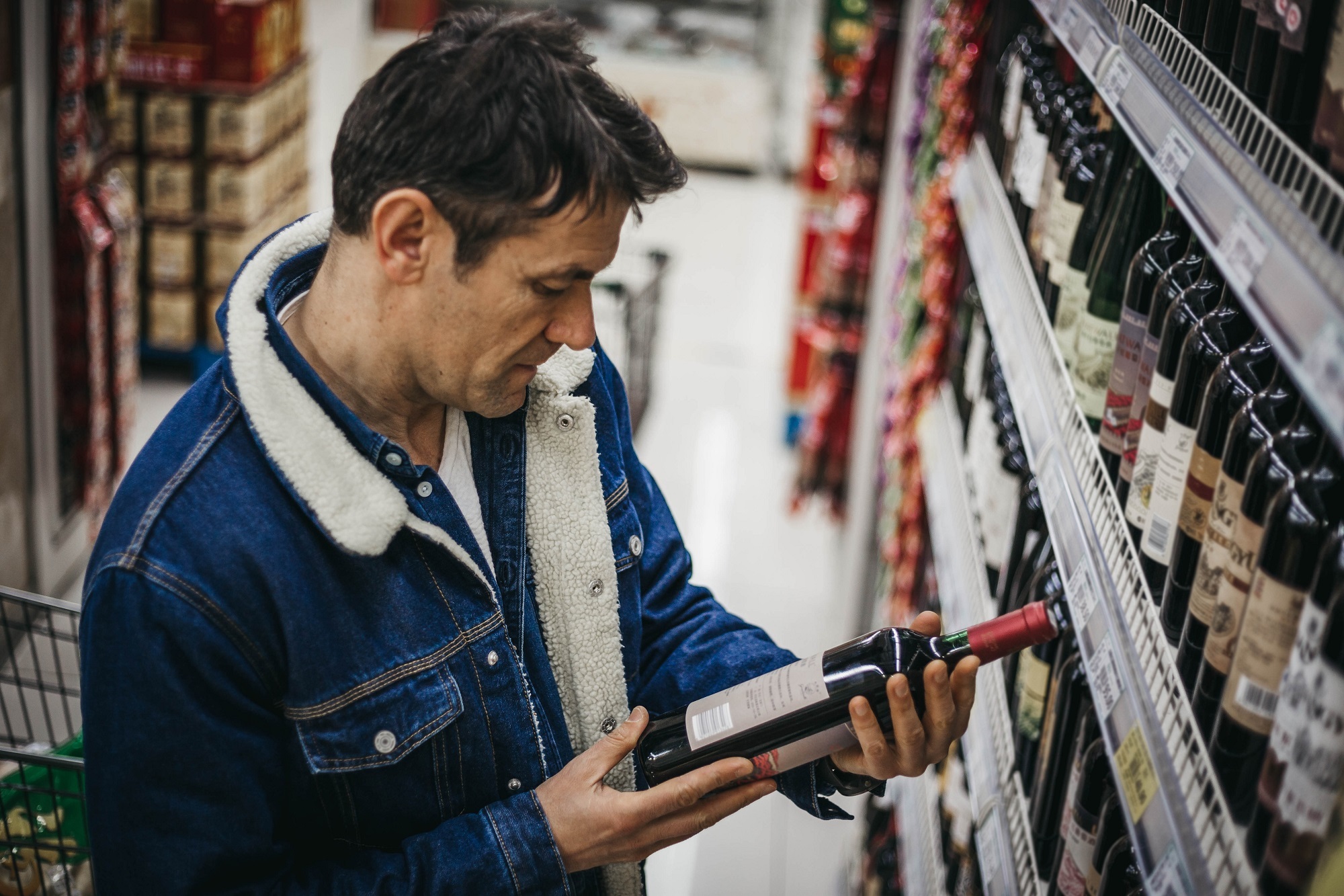 Man choosing wine in supermarket