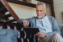Mature man using digital tablet at home 2