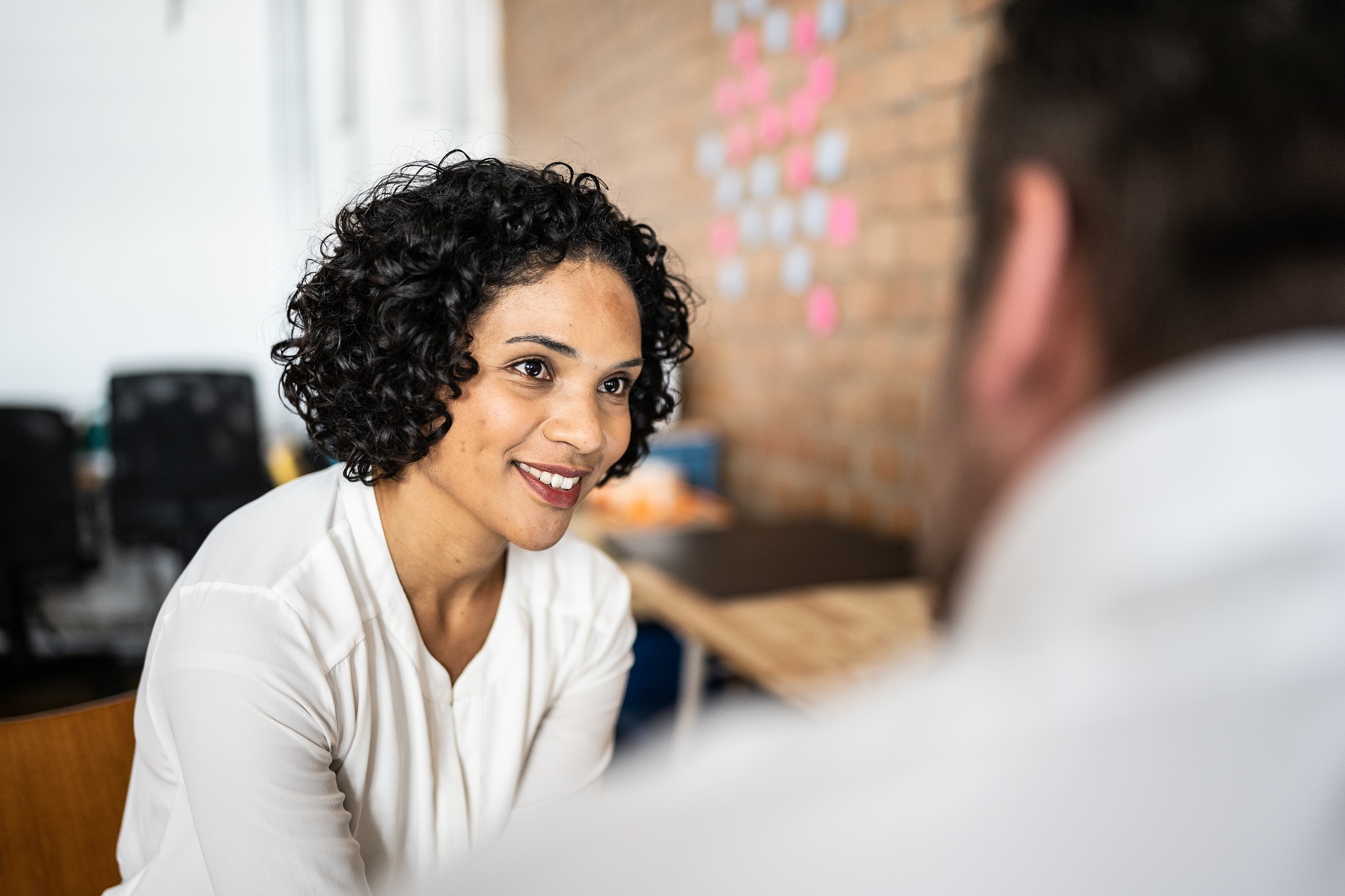 Mid adult woman talking with a colleague at work