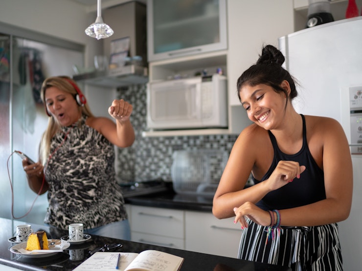Mother and daughter dancing in kitchen
