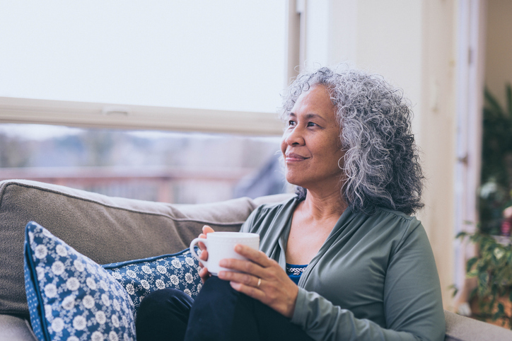 Older adult looking outside on sofa