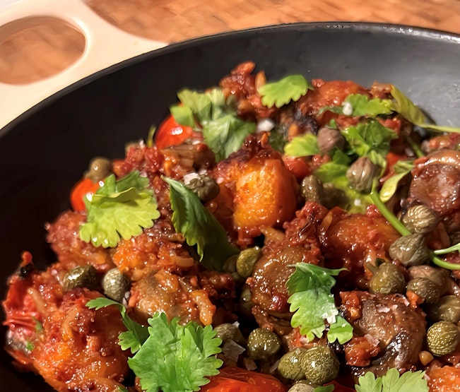 A plate of Puerto Rican alcohol-free corned beef hash, served with fresh coriander and capers.