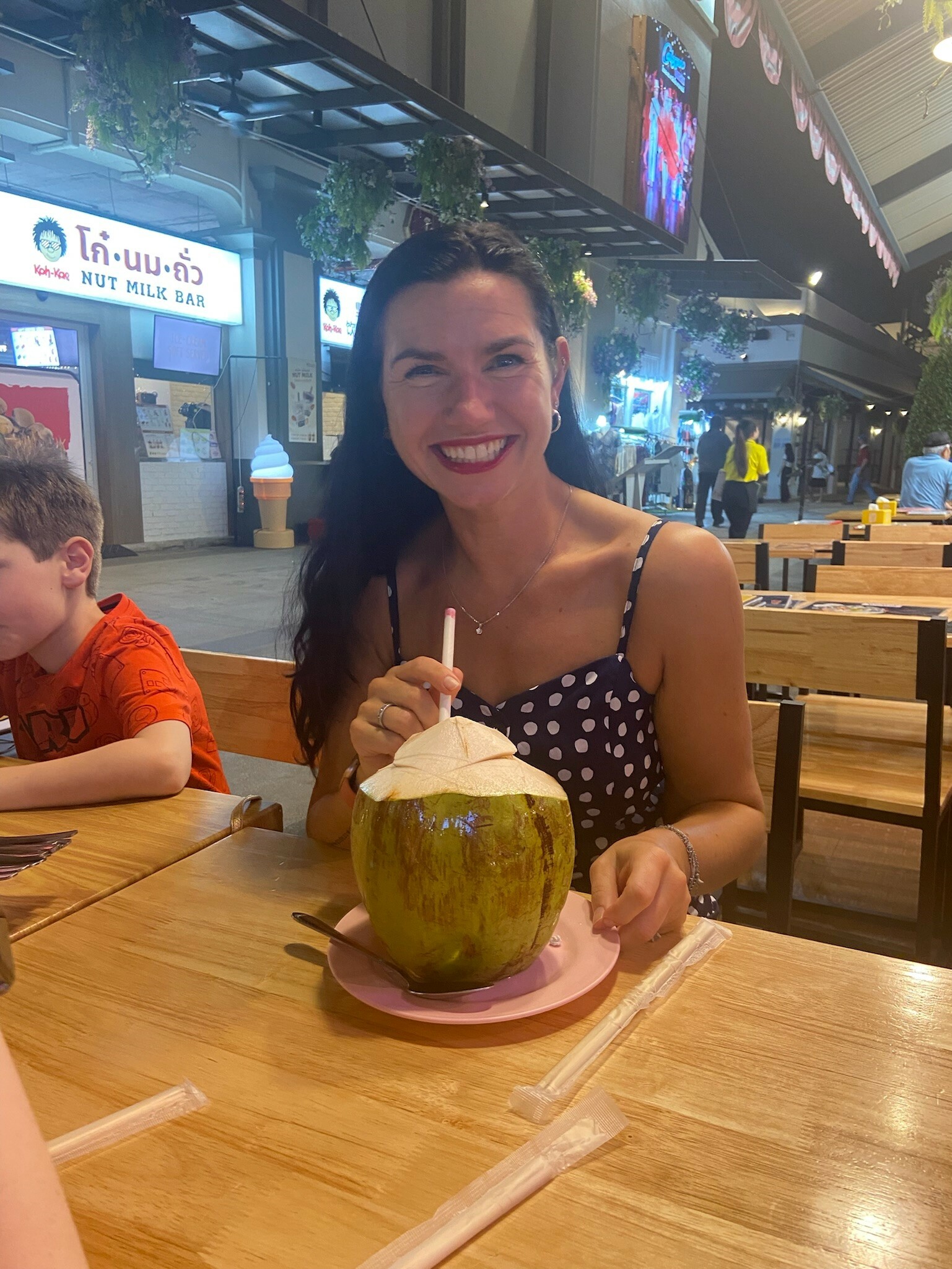 A woman with a cocktail smiles.