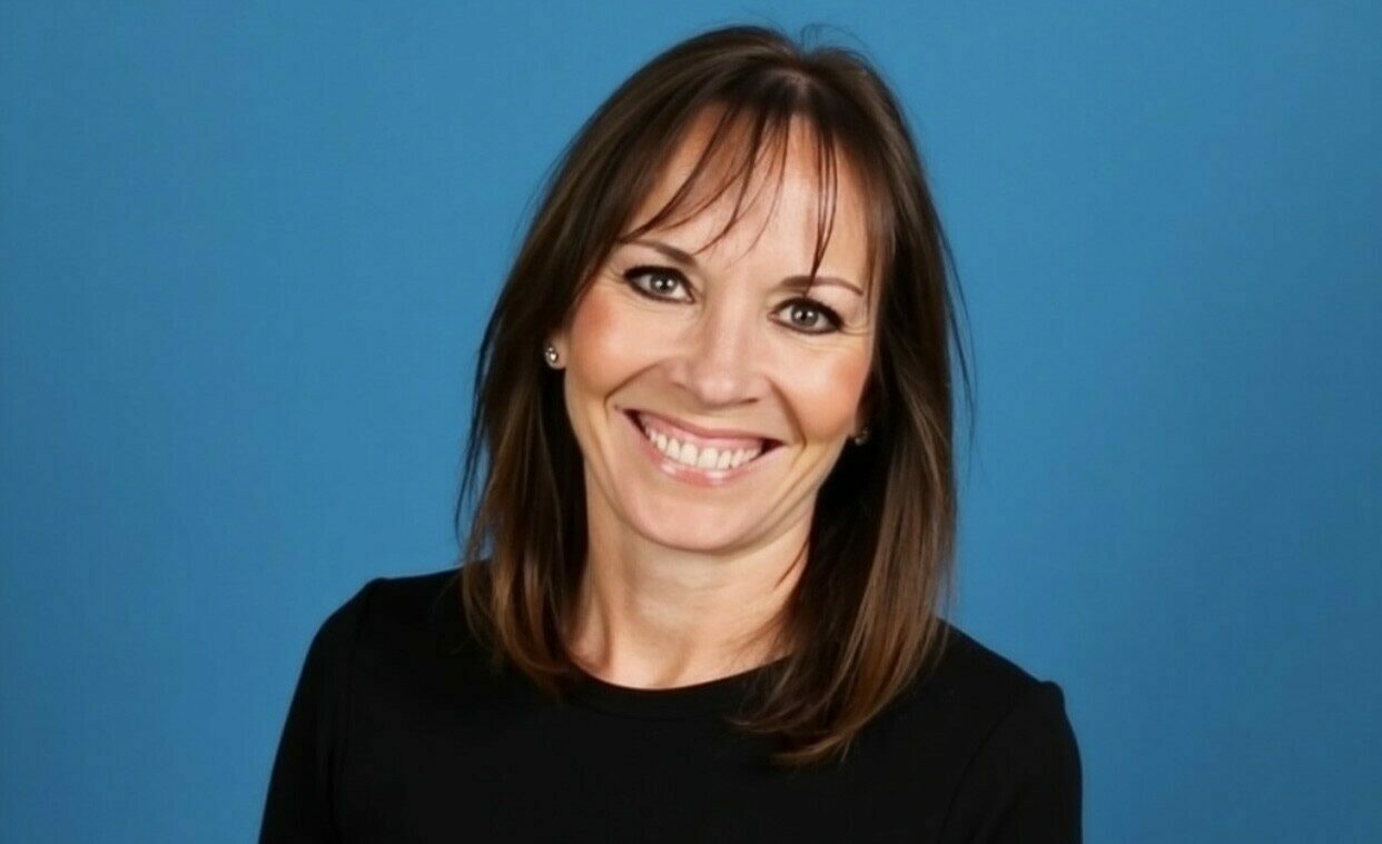 Susan wearing a black top smiling directly at the camera