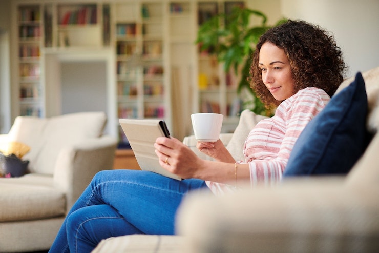 Woman looking at tablet on sofa