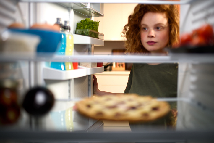 Woman looking into fridge small