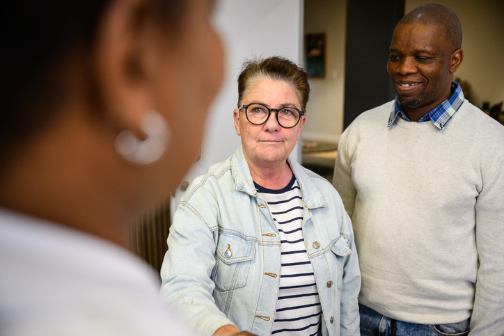 Woman standing with friend and oncologist