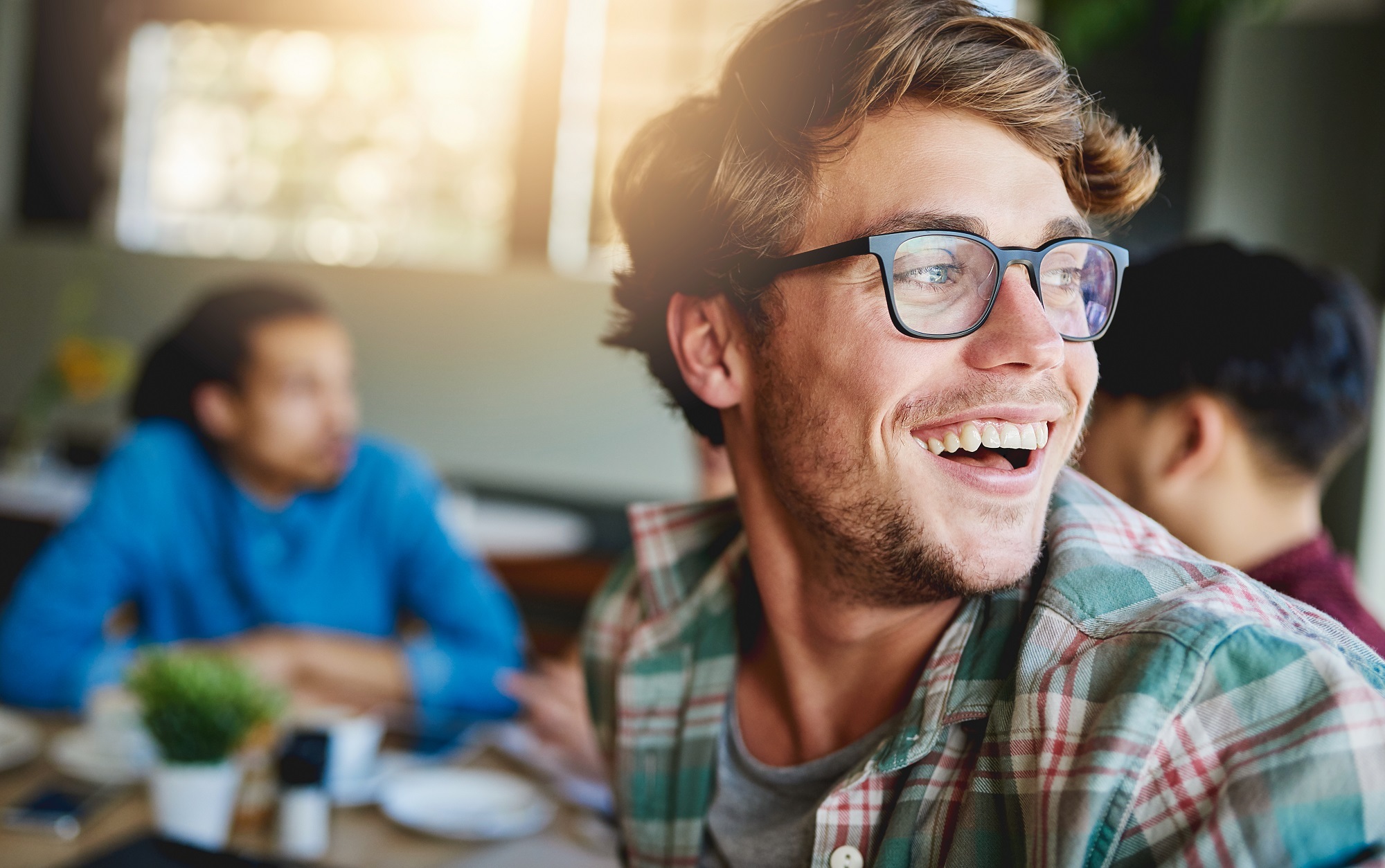Young man sitting at restaurant with friends