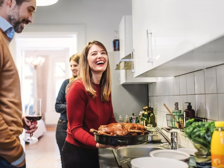 Young Woman Smiling And Holding Christmas Poultry In Kitchen Istock 870412366