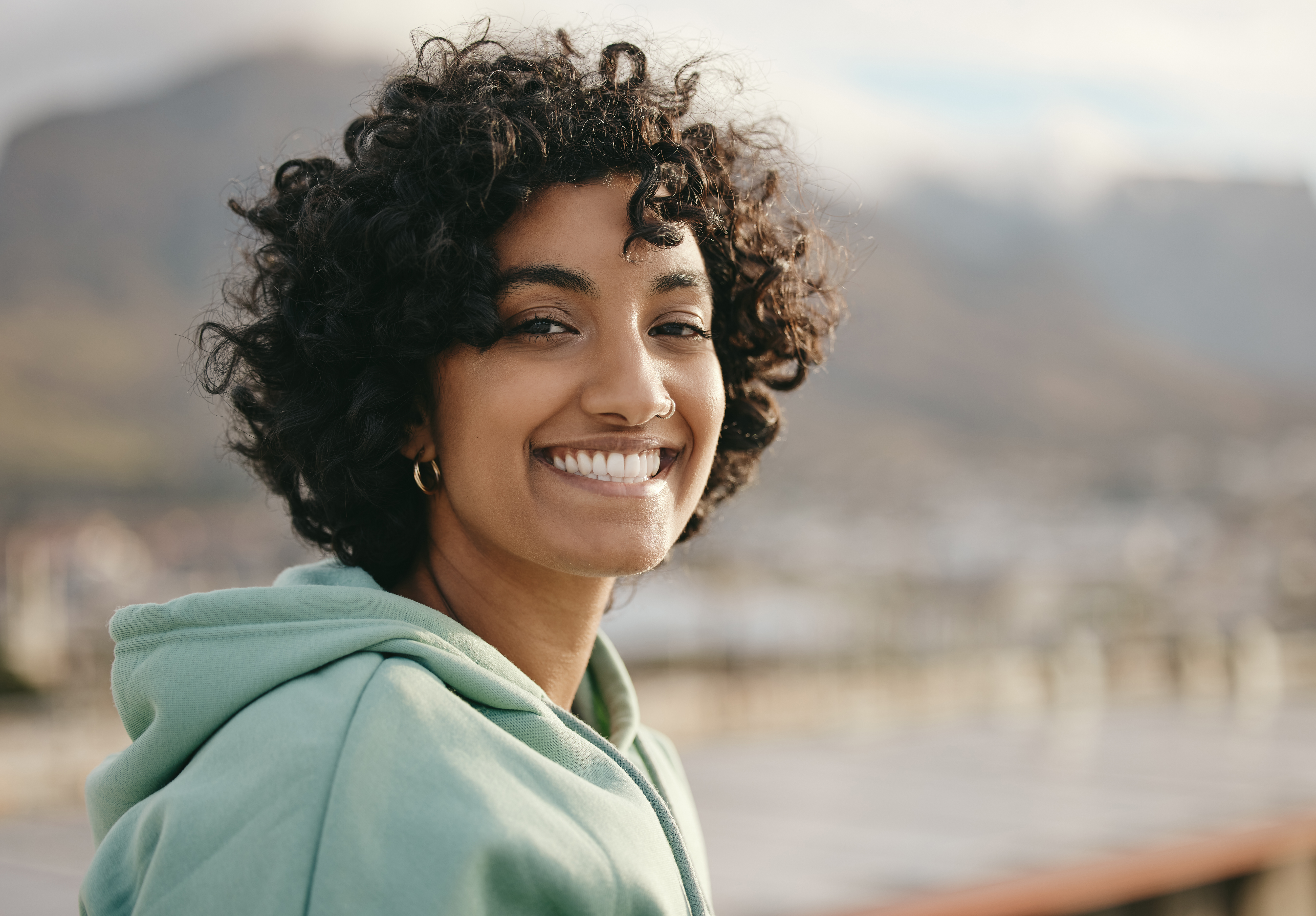 Young woman looking at camera smiling with a positive attitude at the start of the day