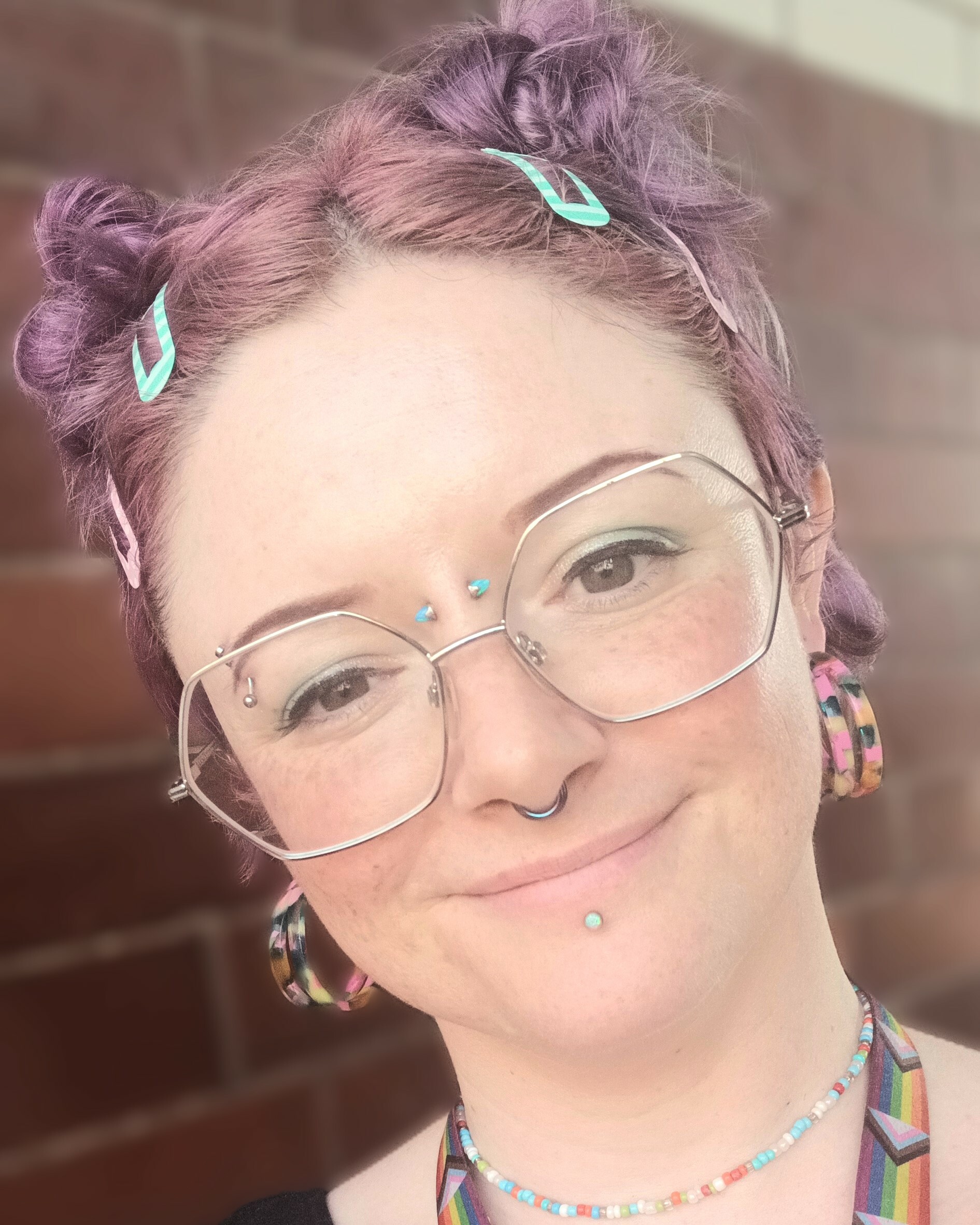 Picture of Celeste smiling directly at the camera with their head slightly tilted to the side